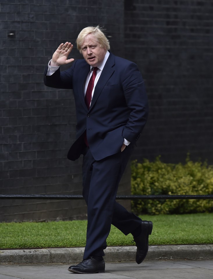 Boris Johnson waves to media as he heads into No10 to speak with the new Prime Minister