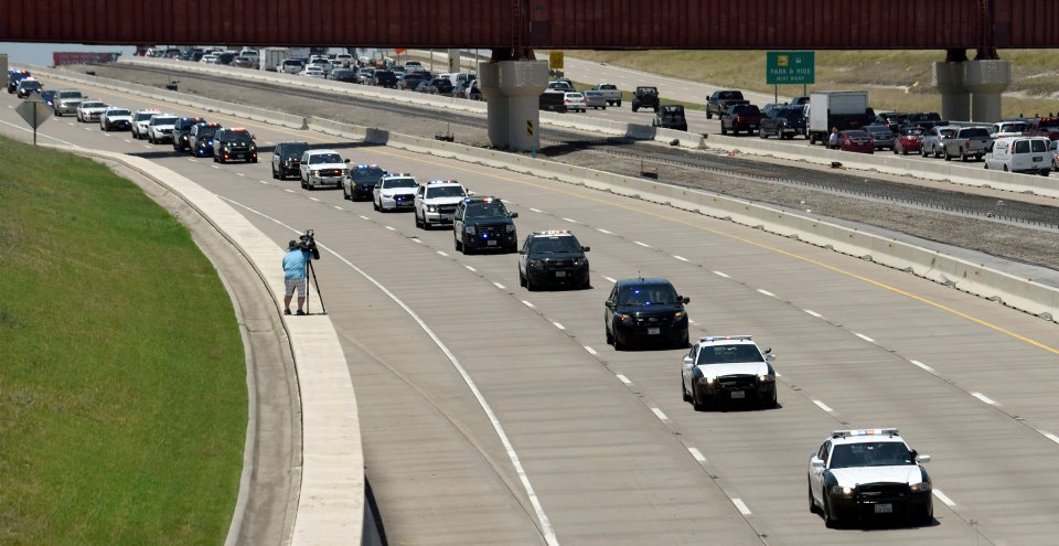 Police cars from different departments make up a funeral procession for slain Dallas Police Senior Corporal Lorne B. Ahrens, who was among five police officers shot dead the previous week, in Dallas, Texas