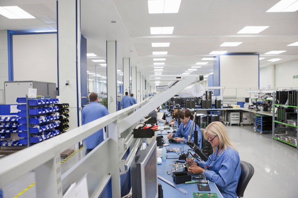Technicians working on assembly line in hi-tech electronics manufacturing plant