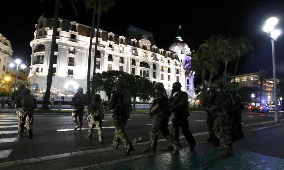 French soldiers advance on the street after at least 30 people were killed in Nice, France, when a truck ran into a crowd celebrating the Bastille Day national holiday