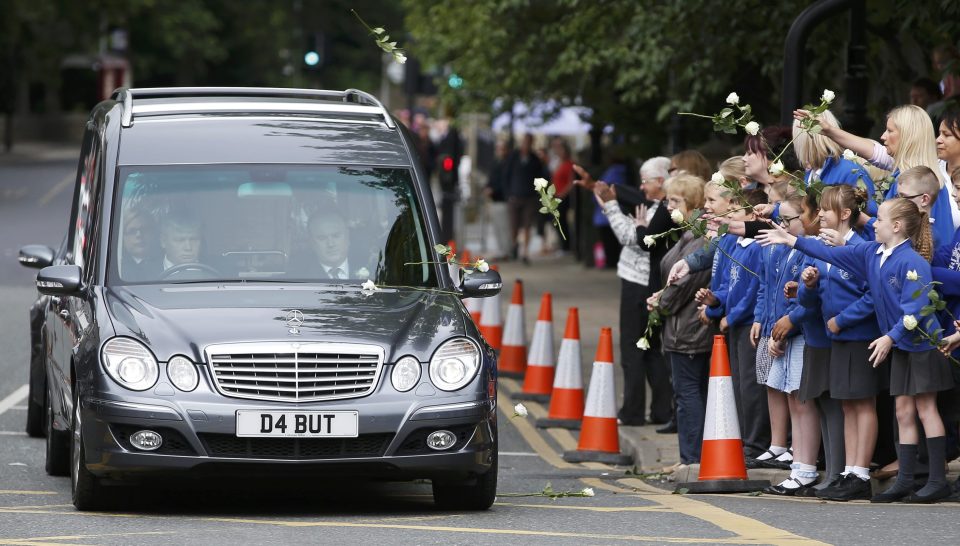 Schoolchildren and teachers throw flowers on to the hearse carrying murdered Member of Parliament Jo Cox's as her funeral cortege will passes through Heckmondwike