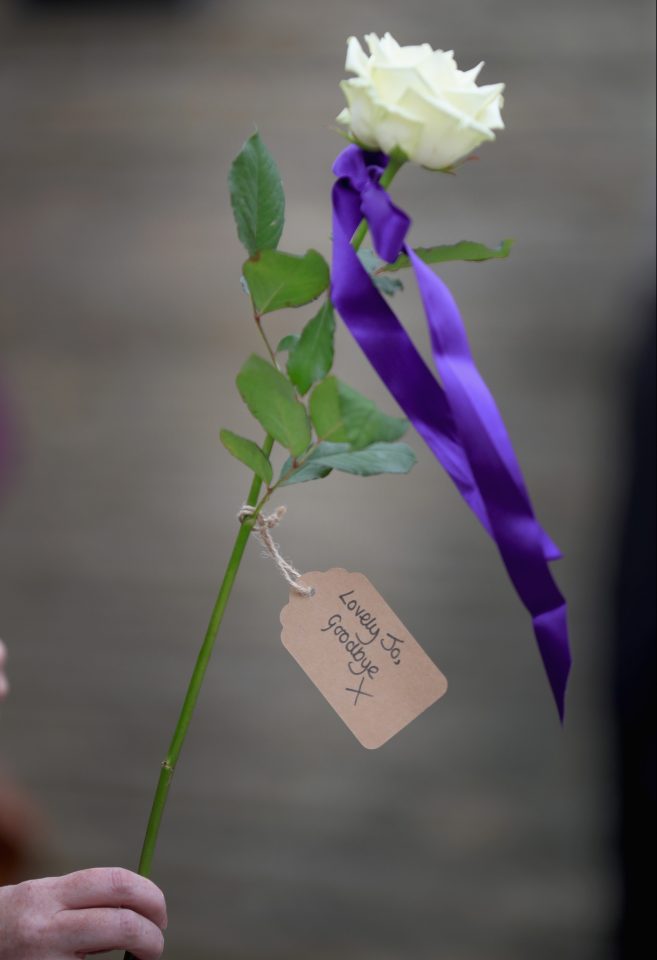 A single flower held by a mourner at the funeral cortege this morning