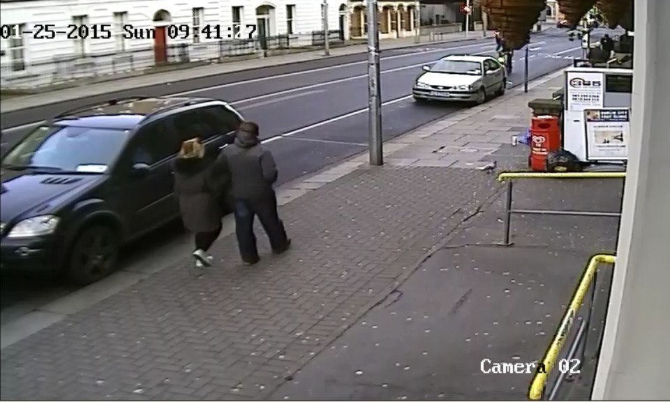 An unidentified man walks past rapist James Fitzgerald, who is begging just off camera
