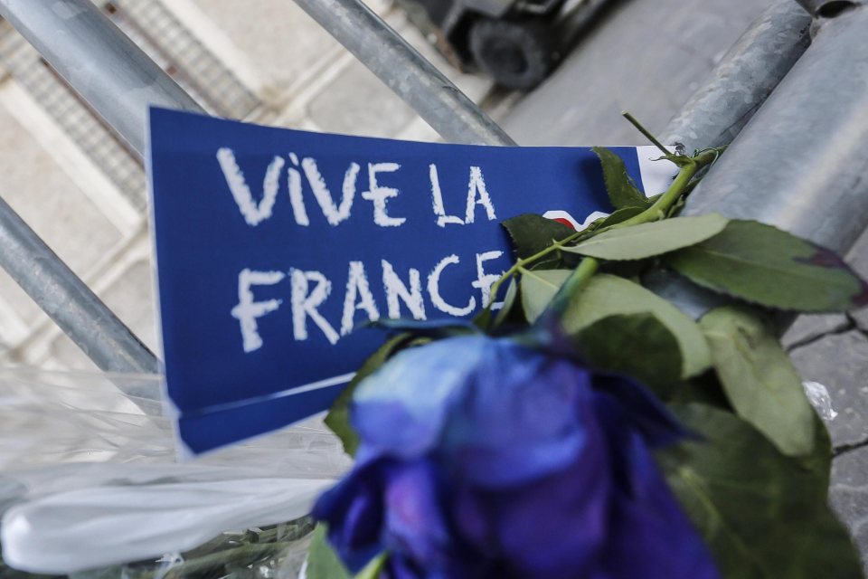 A floral tribute and message reading 'Vive la France' is left at a fence erected outside the French Embassy in Rome. part of the outpouring of grief