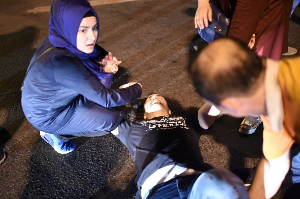 A woman helps a man shot after clashes with Turkish military at the entrance to the Bosphorus bridge