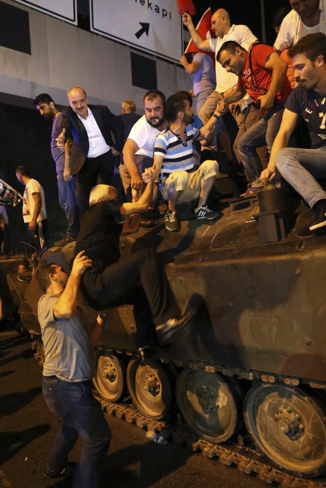 Protesters have clambered onto tanks involved in the military-led coup