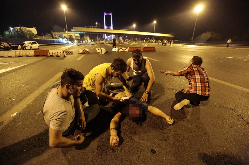 People desperately try to help a man, believed to have been shot after clashes between protesters and the military 