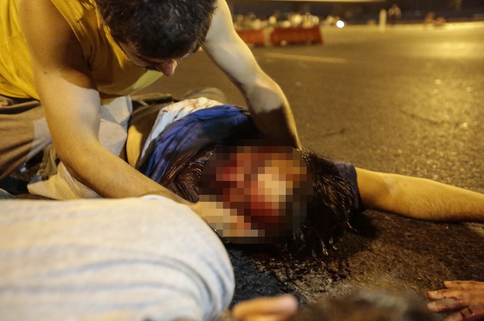 A heavily wounded man lies on the ground at the entrance of Bosphorus bridge