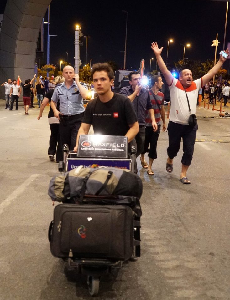 Passengers leave the Ataturk Airport as Turkish army tanks enter 