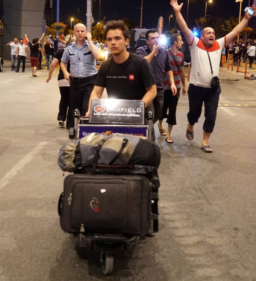 Passengers leave the Ataturk Airport as Turkish army tanks enter