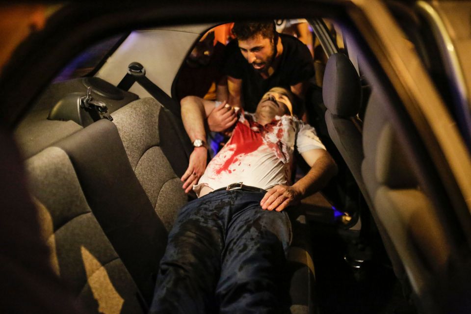 People carry a man shot during clashes with Turkish military 