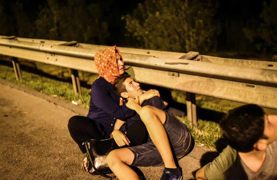 People take cover during clashes with Turkish military at the entrance to the Bosphorus bridge