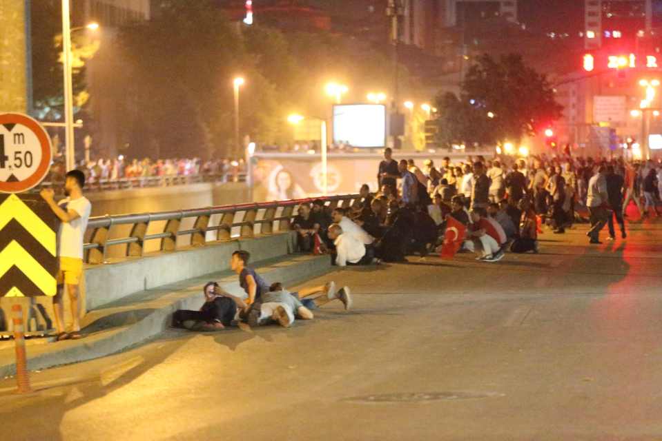 A group of people take cover during the clashes in Ankara