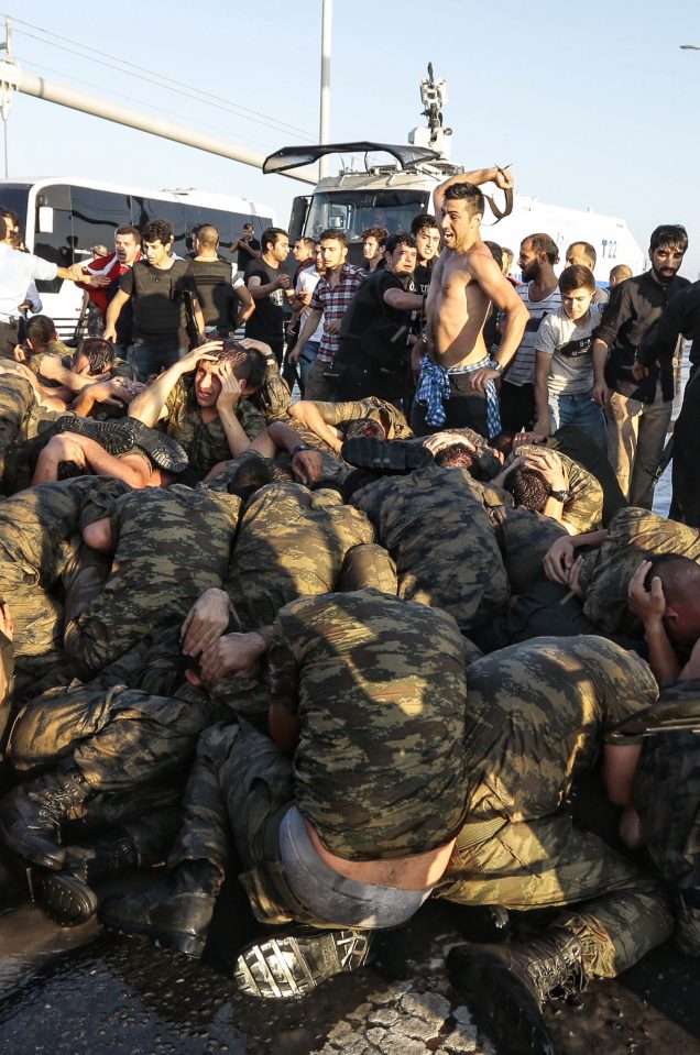 Mob's revenge...An unidentified man uses his belt to hit Turkish soldiers involved in the coup