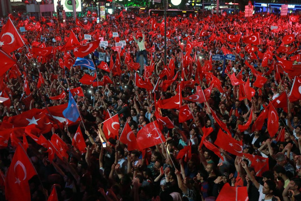 People wave flags as they gather in Kizilay Square in Ankara