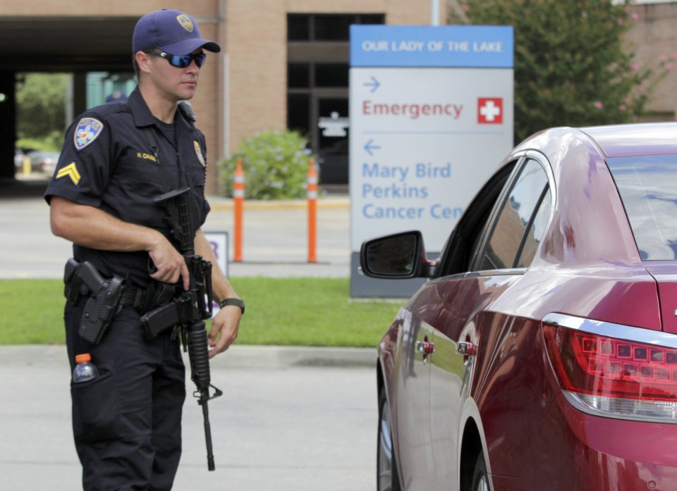A police office armed with a rifle guards the entrance to Our Lady of the Lake Hospital after a fatal shooting of police officers in Baton Rouge