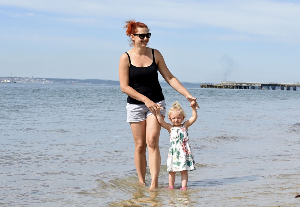 Kinga and her daughter Phoebe paddle in the water at Southsea beach