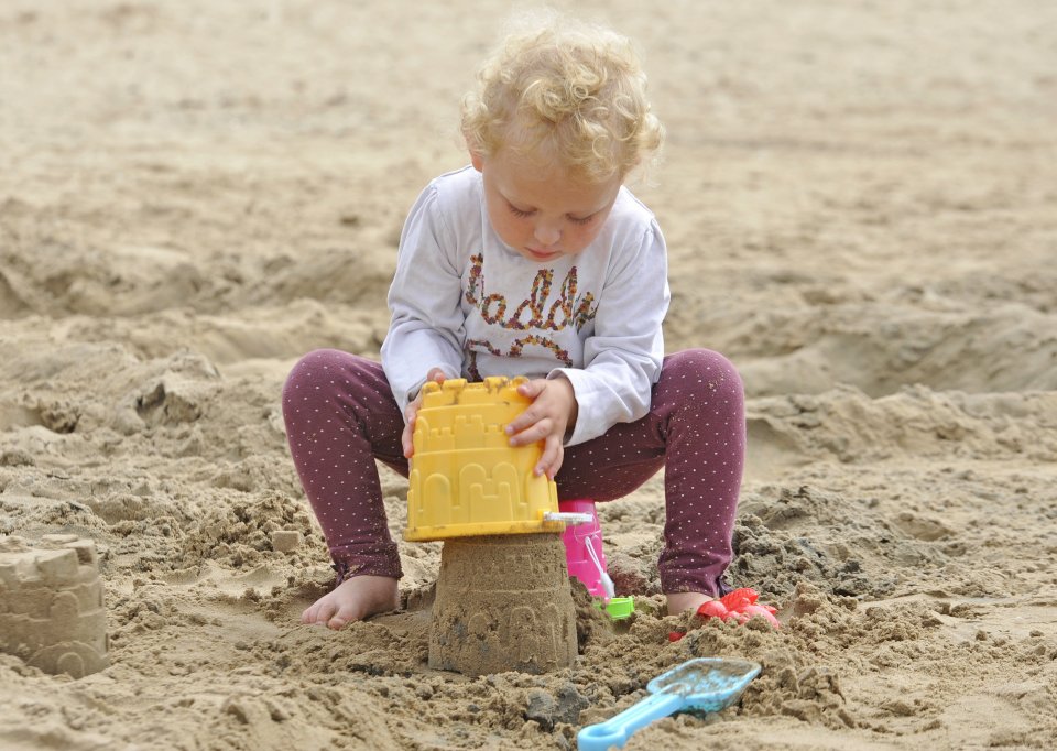 Georgia Jones, 2, from Preston, Lancs., makes sand castles on Lytham St Annes beach on a sunny and warm day on the Lancashire seaside resort