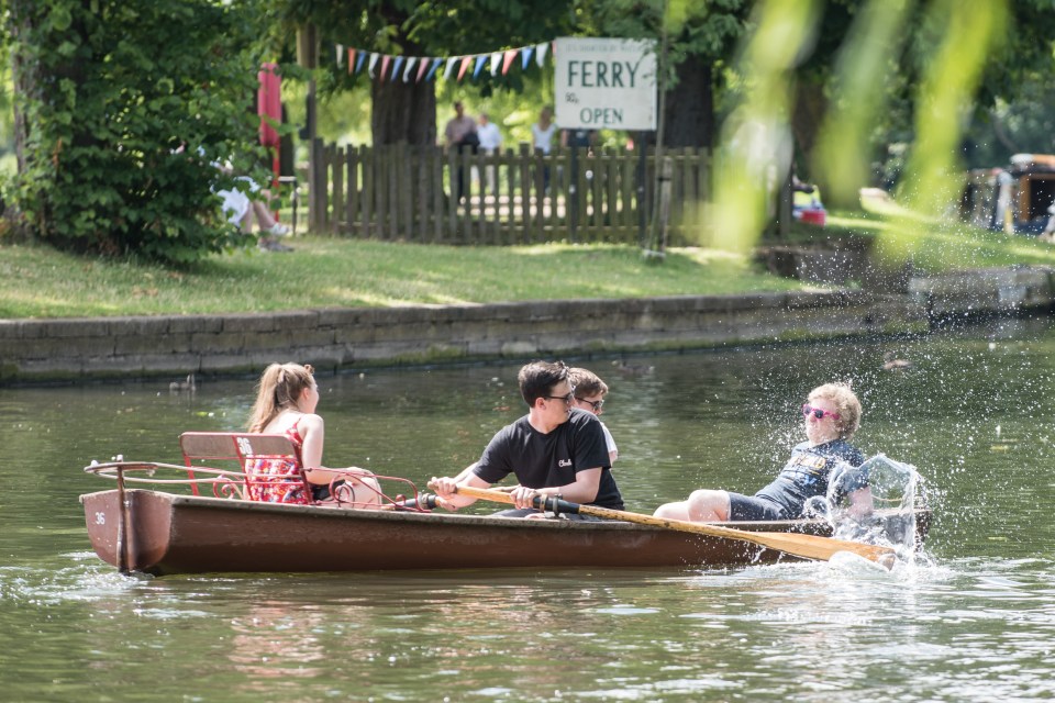 Elsewhere a lad is splashed by his friends as they take a rowing boat out on the River Avon in Straford-upon-Avon