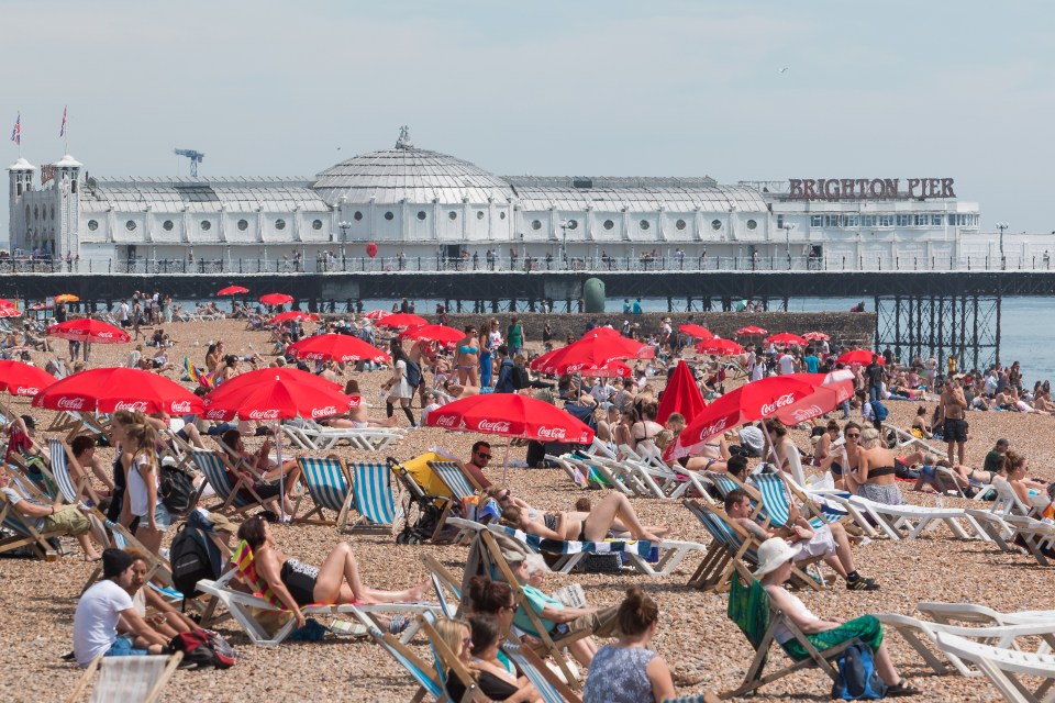 Thousands of people relax and sunbathed on the beach in Brighton on the hottest day of the year