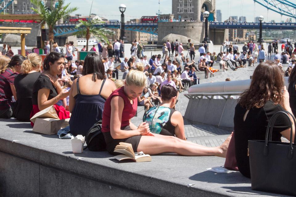 Lunch workers bask in glorious sunshine on London Riverside on a hot day in the capital as temperatures are predicted to soar to 30 
