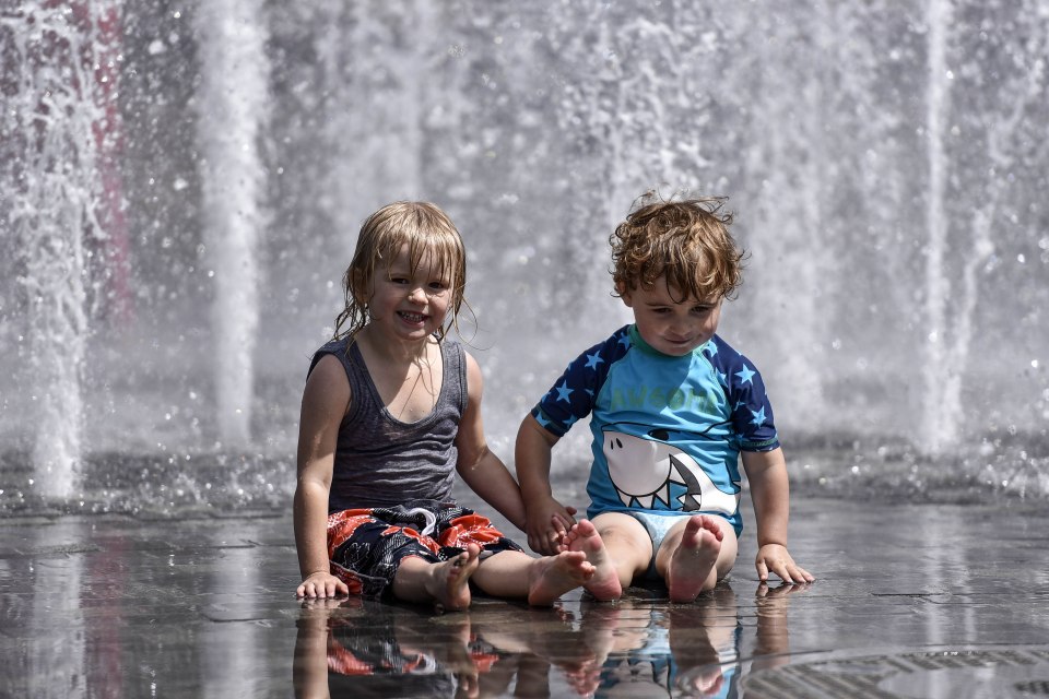 Charlie,three, and Xan, two, enjoy the fountains at City Park, Bradford