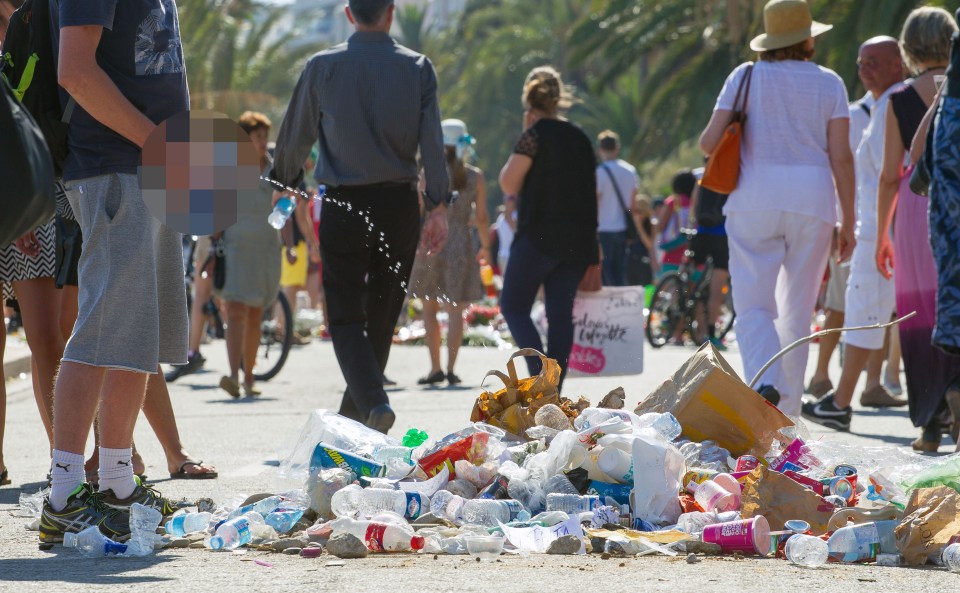 A man relieves himself on the pile of rubbish gathered to shame the driver