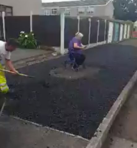 The woman stages her sit-in protest - forcing workers to tarmac around her
