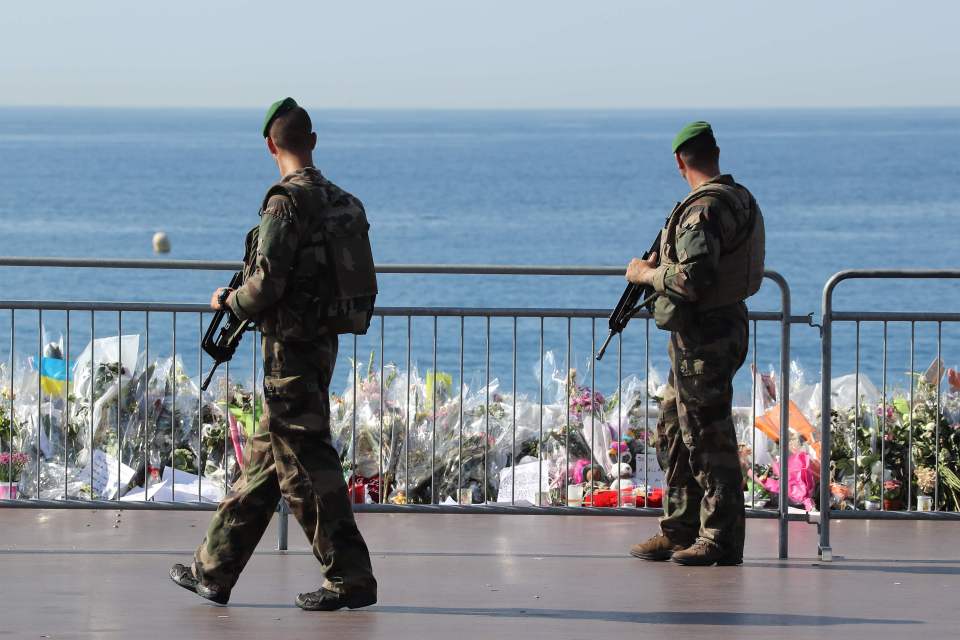 Soldiers pass by the new makeshift memorial in tribute to the victims of the deadly Bastille Day attack at the Promenade des Anglais