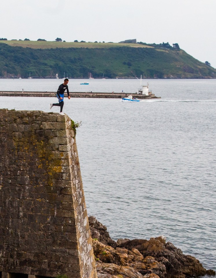 A teenager runs off the cliff edge at Dead Man's Cove in Plymouth