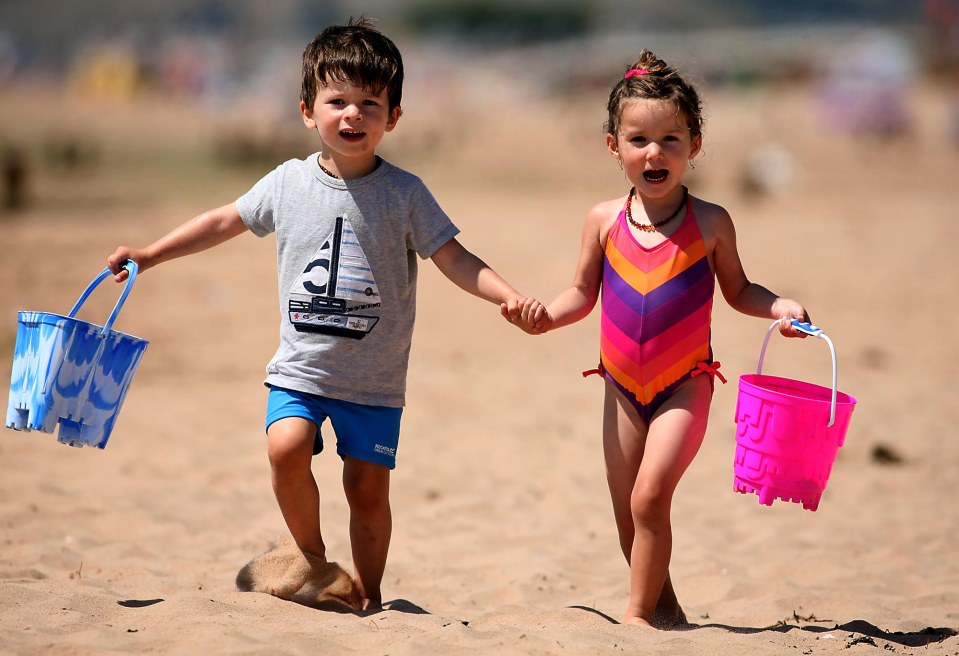 Santiago and Sofia McGarry (both two) enjoy the summer sun at Exmouth, Devon, while most of the country is threatened with thunderstorms and rain