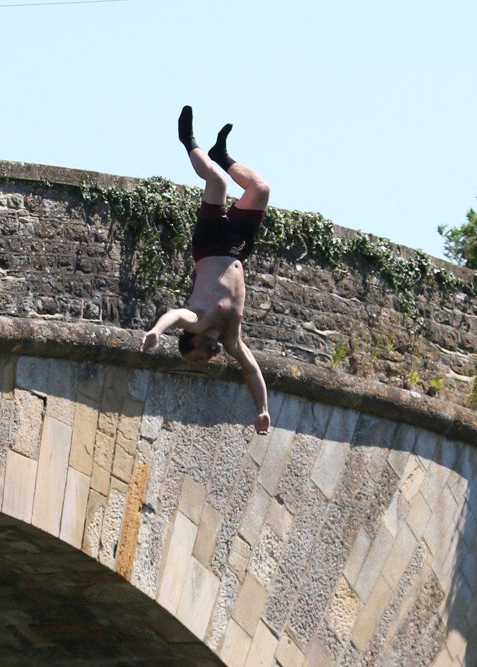 One man wearing socks was doing a backward flip jump in to the water. Buford village, Cotswolds