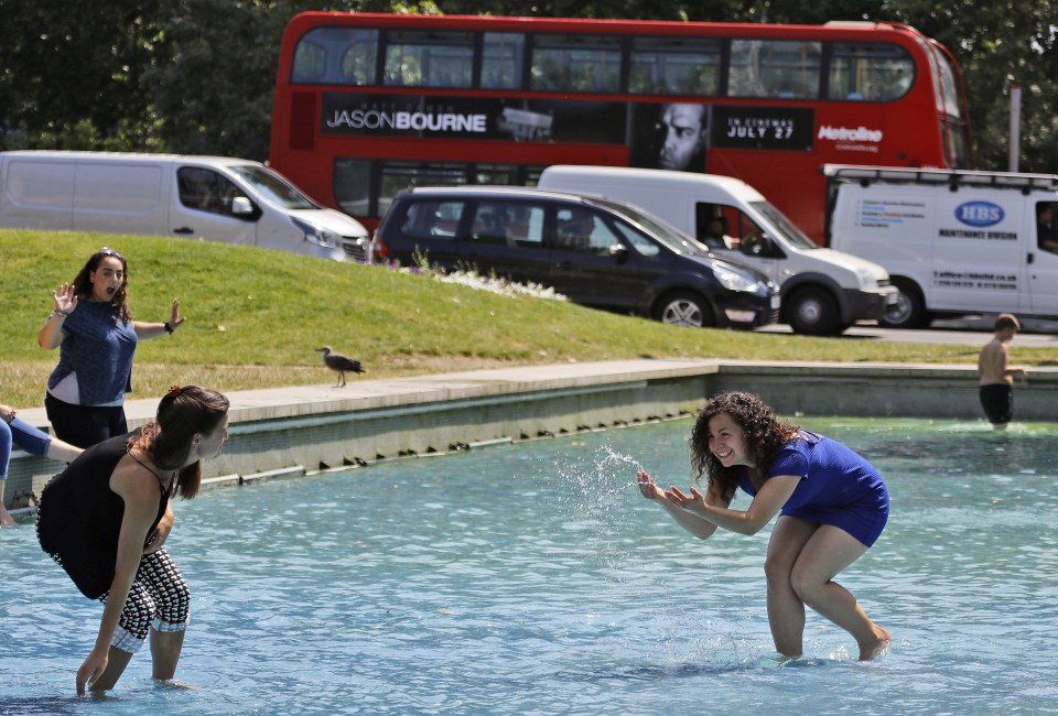 Women splash each other in the cold water of a fountain at Marble Arch in central London on Wednesday