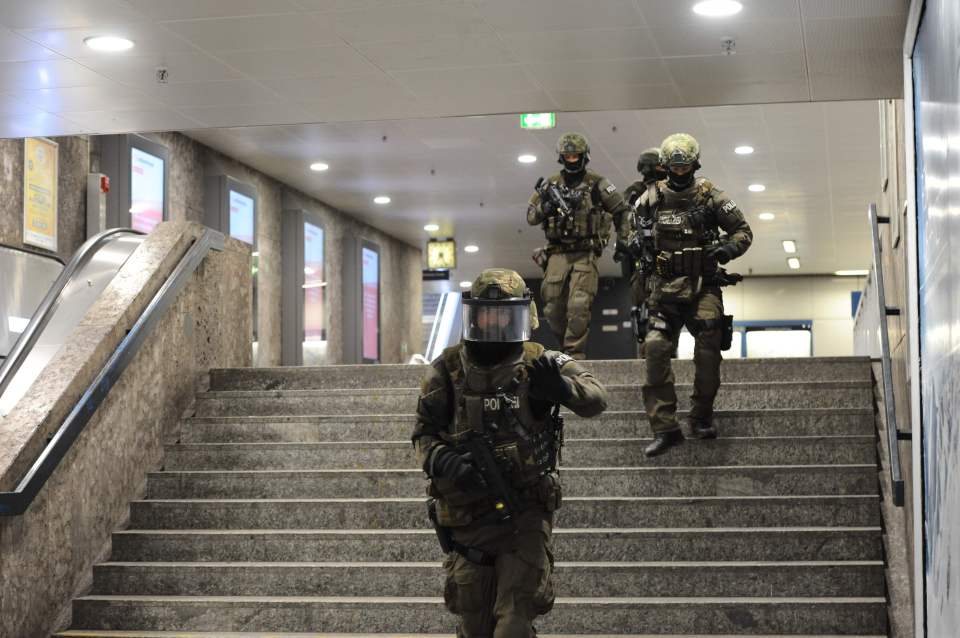 Police patrol the subway as a manhunt is underway for the shooters
