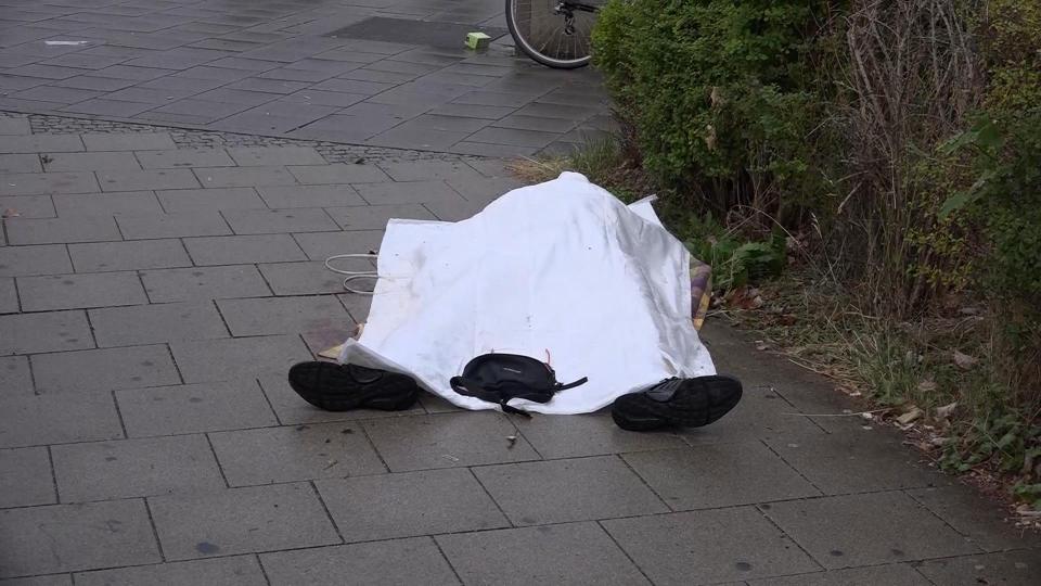 A body lies covered in the street following the shootings 