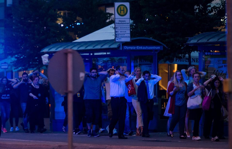 People made their way away from the mall with their hands in the air under a police escort