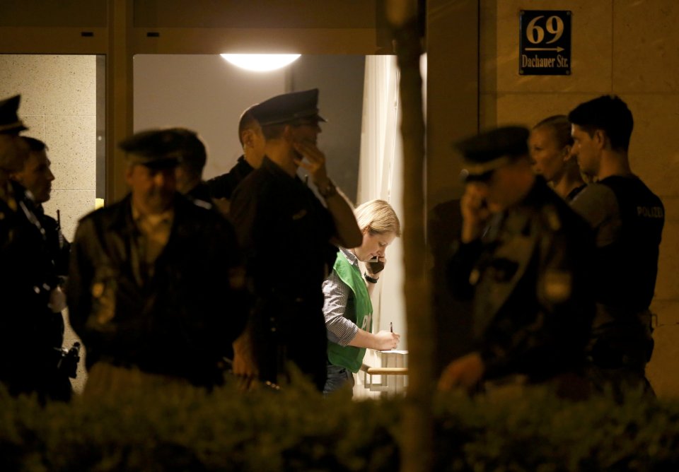 Police officers are on their way to search an appartment building following a shooting rampage at Olympia shopping mall in Munich