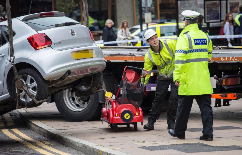 Police work to remove a child's toy car at the crash site