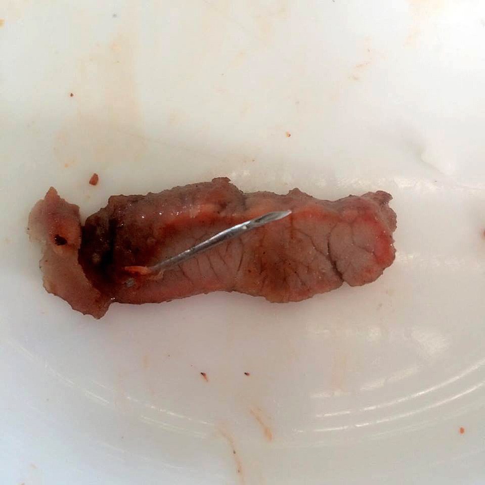 A Thai woman got a nasty shock when she bit into a piece of pork to find an inch long needle inside