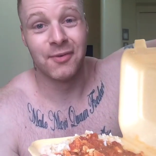 The convicted kidnapper holds up a prison curry before pushing it away to show himself holding Mcdonalds cheeseburgers 