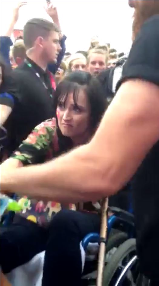 The tearful mum looks resigned as she is taken back through the crowd against her will