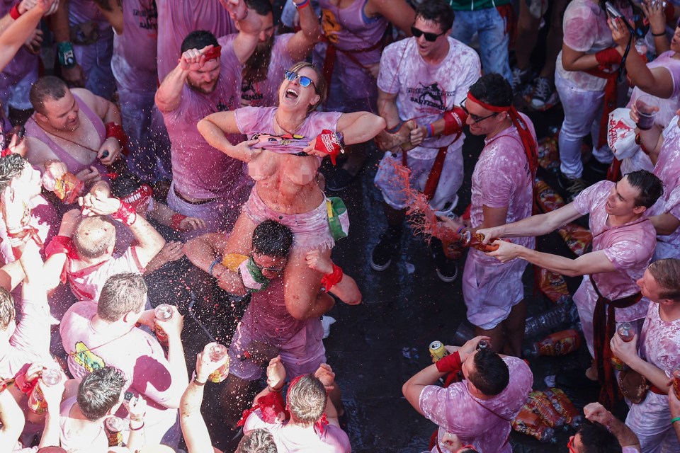 A woman perched on a man's shoulders joins in the fun in Pamplona, as the world renowned nine-day festival gets off to a lively start