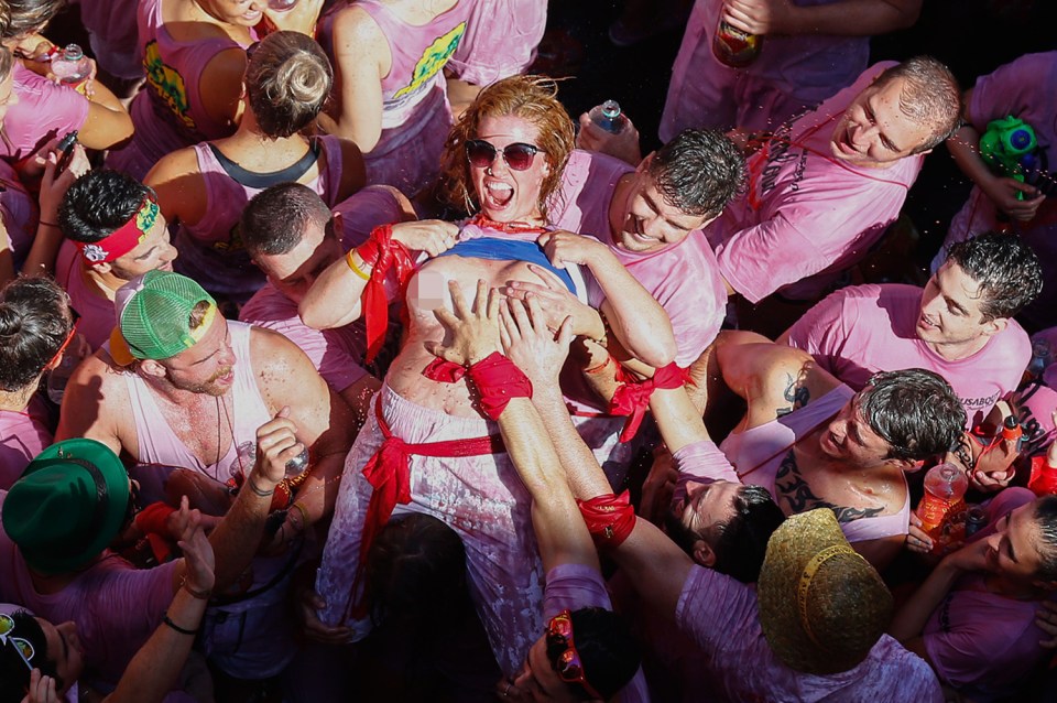 Handymen: A woman lays back and allows men to grope her at the start of the nine-day 'running of the bull' festival