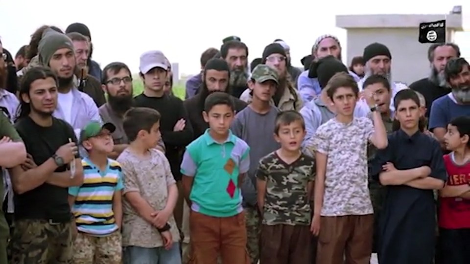 A crowd of young men and boys gather to watch the sick execution