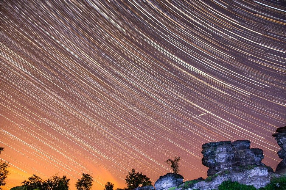A time lapse photograph captures shooting stars streaking across the night sky over the Yorkshire dales