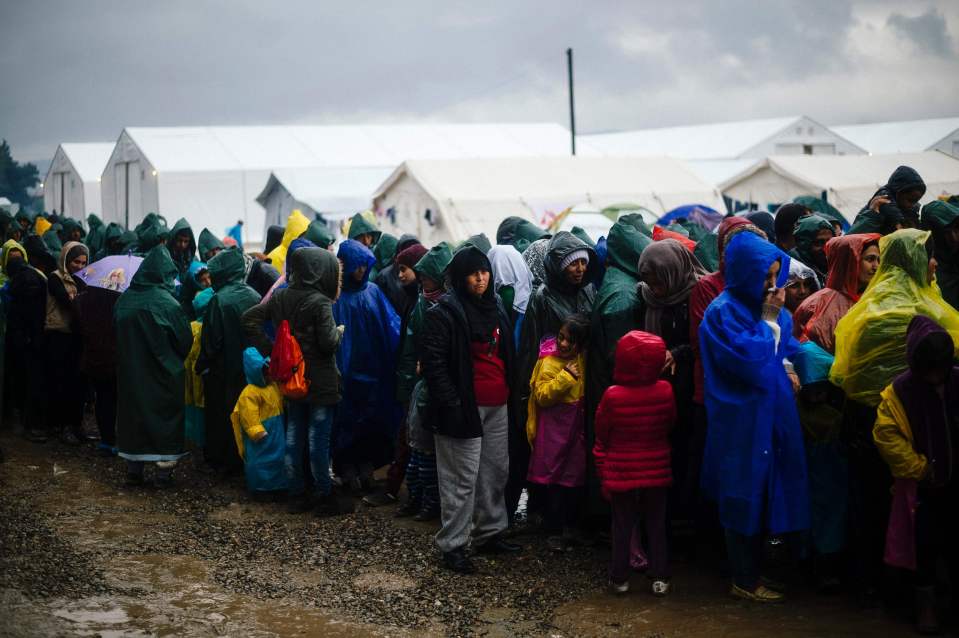 People queue in the rain for soup on Mar