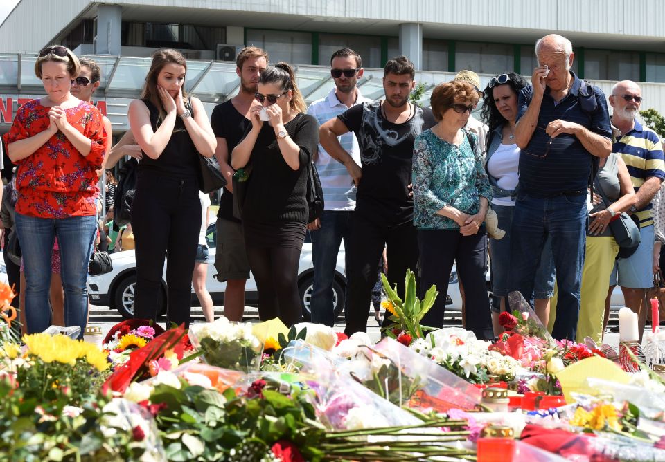 People mourn at a memorial of candles an