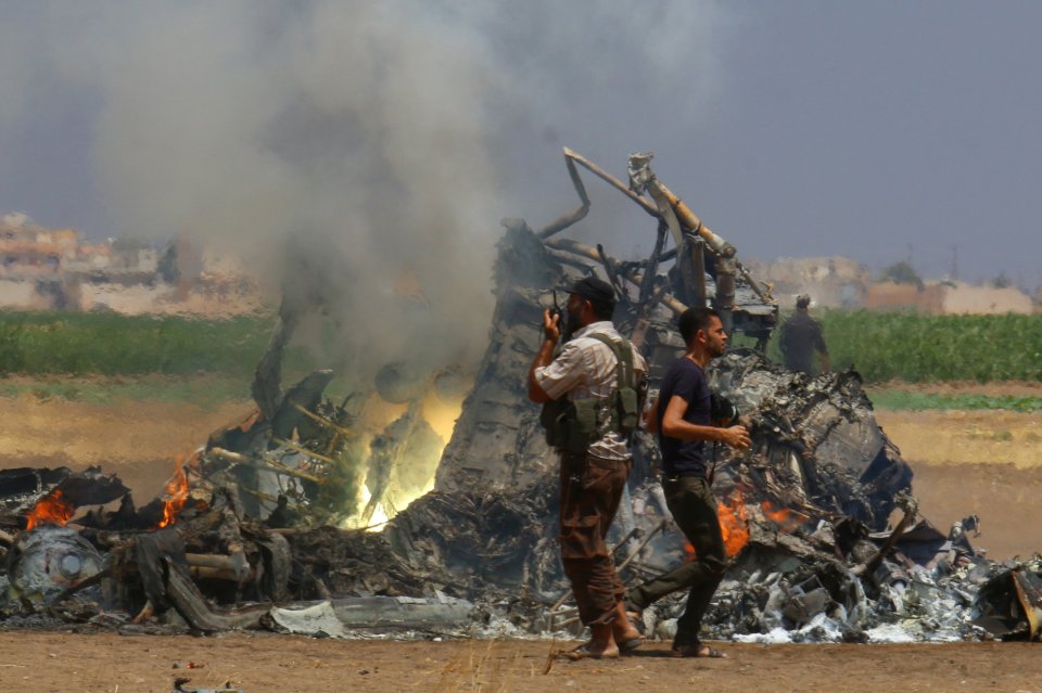 The destroyed wreckage of the plane is inspected by rebels in northern Syria after it was brought down on Monday morning