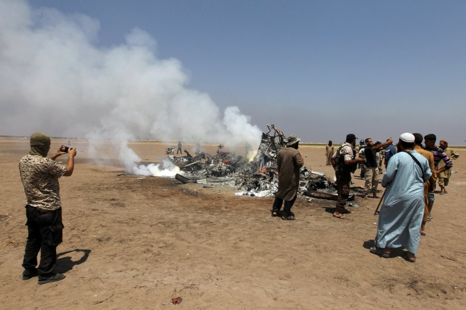 Rebels take photos of the wreckage after it came down in the northern Idlib region