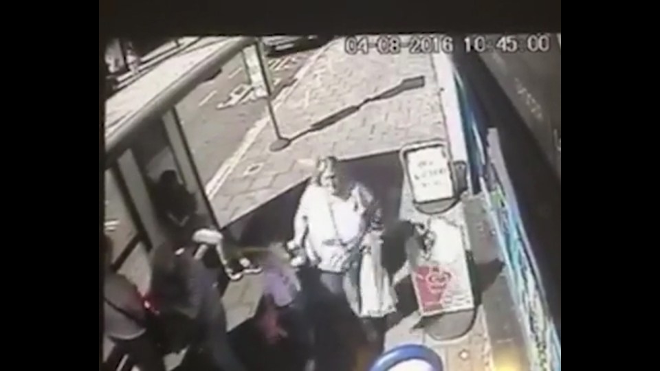 A terrified woman with a young child can be seen running away from the scene